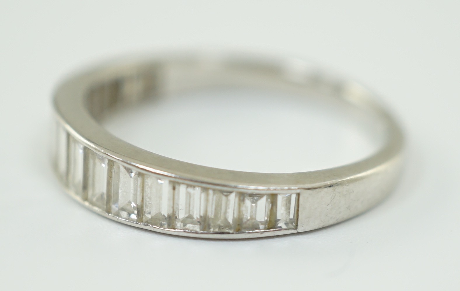 A platinum? and graduated seventeen stone baguette cut diamond set half eternity ring